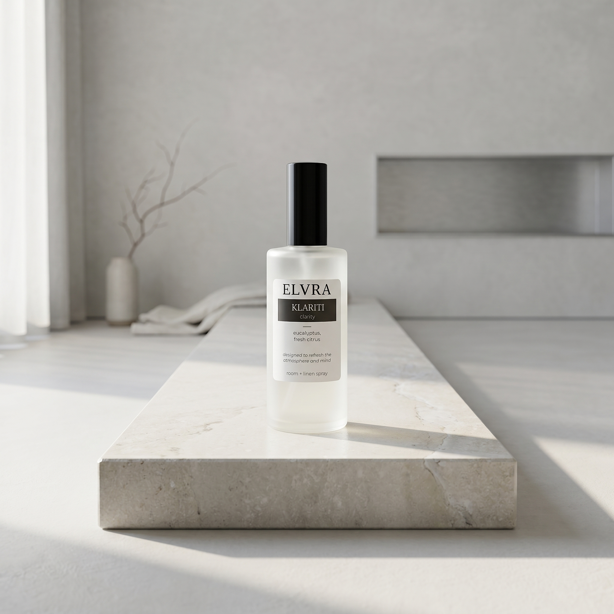 ELVRA KLARITI mist bottle centered on pale stone plinth in a minimal chalk-plaster room with soft daylight.