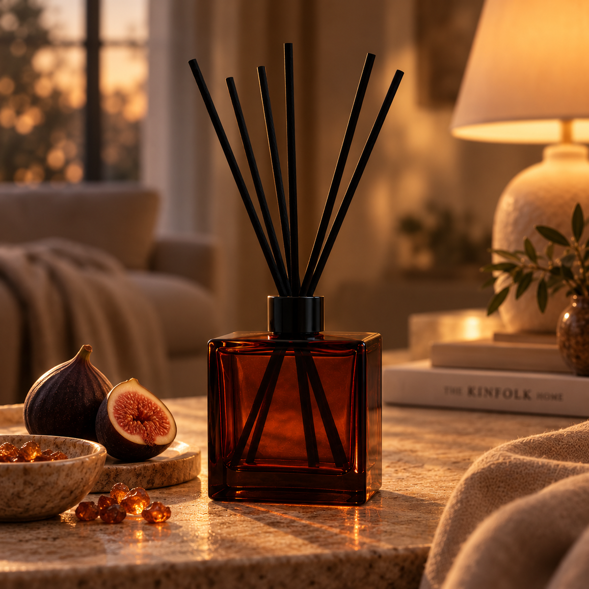 ELVRA Figné Glow reed diffuser styled with figs, warm stone, amber accents, and soft textiles in a cozy evening setting.
