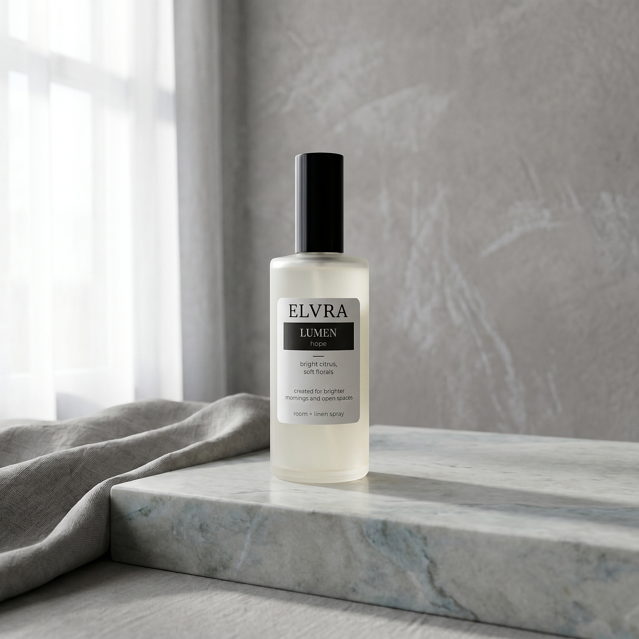 Frosted ELVRA LUMEN atmosphere mist bottle on pale stone with soft gray plaster, linen drape, and diffused window light.
