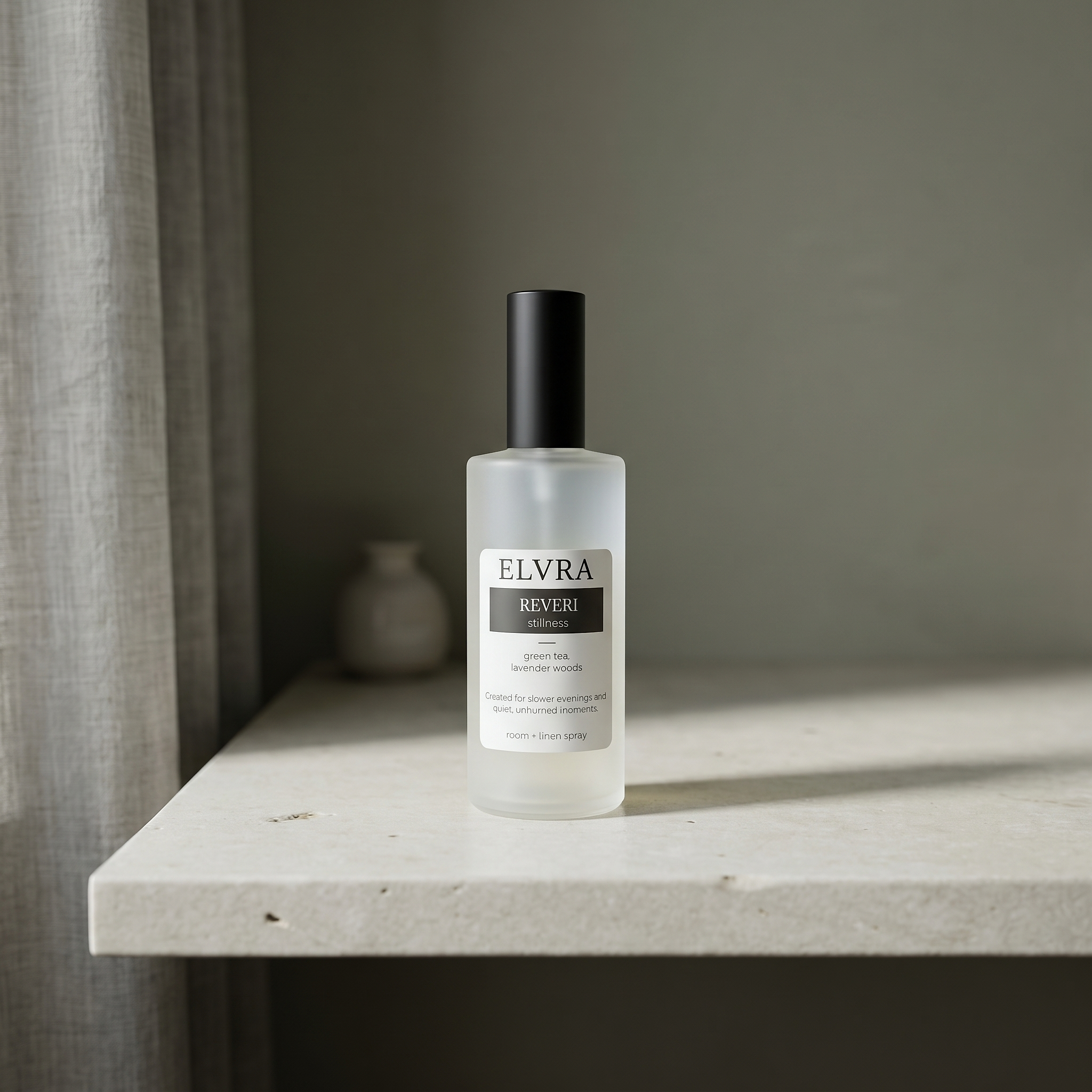 Elvra REVERI atmosphere mist bottle on pale stone with soft daylight, linen, and blurred muted interior details.